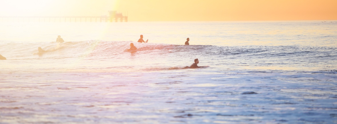 surfers in sea at dusk